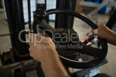 Mid-section of man driving a forklift car