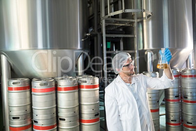 Scientist examining beer in beaker