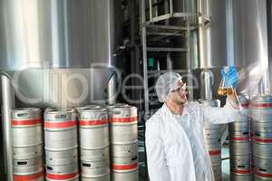 Scientist examining beer in beaker