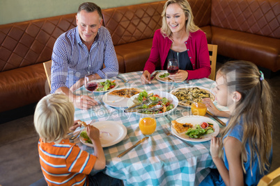 High angle view of happy family dining at restauranrt