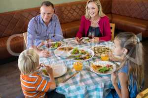 High angle view of happy family dining at restauranrt