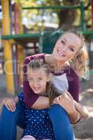 Happy mother and daughter enjoying at playground