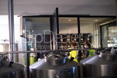 Workers examining pressure gauge at brewery