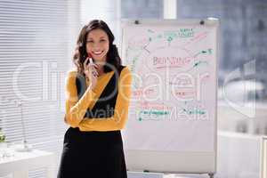 Female executive standing in front of flip chart at office