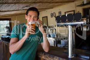 Man drinking beer while talking on mobile phone