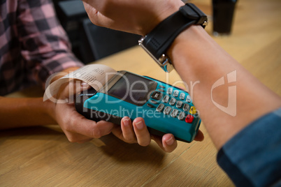 Cropped hand of customer making payment at bar