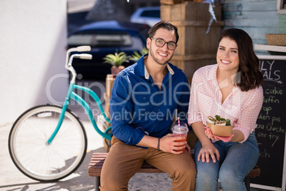 Smiling couple sitting with snacks and juice