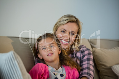 Mother and daughter embracing each other in the living room at home