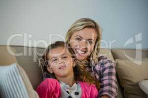 Mother and daughter embracing each other in the living room at home