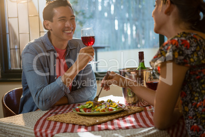 Happy man with female friend having red wine