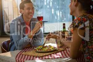 Happy man with female friend having red wine