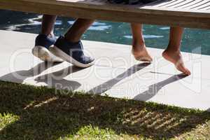 Father and son sitting on bench in the backyard