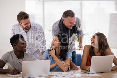 Business colleagues interacting with each other while working together