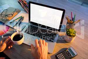 Male executive working over laptop at his desk