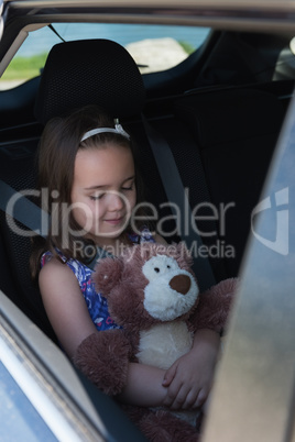 Cute girl holding teddy bear while sleeping