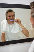 Man brushing his teeth in bathroom