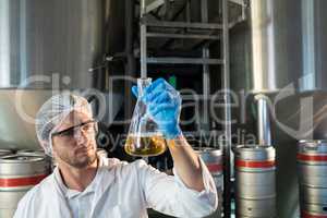 Scientist examining beer at factory