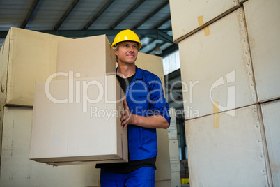 Worker holding a cardboard boxes while walking