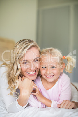 Mother and daughter relaxing in the bedroom at home