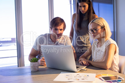 Executives discussing over laptop during a meeting