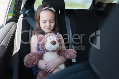 Cute girl holding teddy bear while sleeping