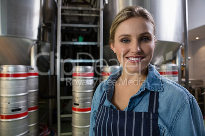 Portrait of beautiful worker standing by storage tank