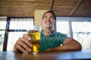 Happy man with beer glass looking away