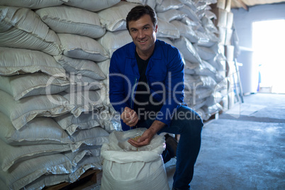 Portrait of smiling worker examining barley