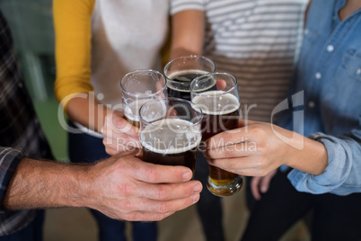 Cropped hands of friends toasting drinks