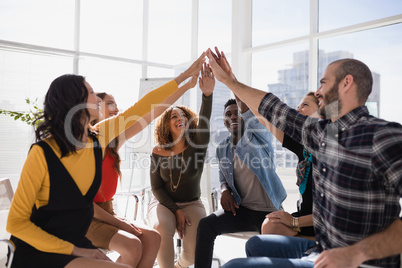 Group of happy executives giving high five to each other