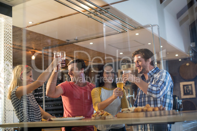 Cheerful friends toasting drinks at restaurant