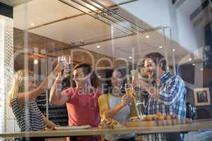 Cheerful friends toasting drinks at restaurant