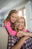 Mother and daughter embracing each other in the living room at home