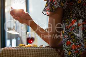 Midsection of woman holding wineglass