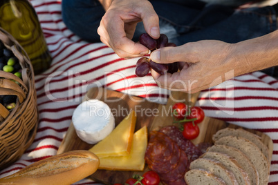 Mid-section of man holding a bunch of olives