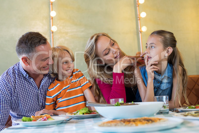 Happy family talking dining at restaurant