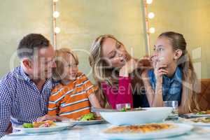 Happy family talking dining at restaurant