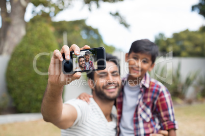 Happy father and son talking selfie