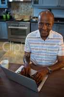 High angle view smiling senior man using laptop