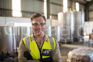 Portrait of happy technician standing with arms crossed