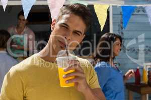 Young man having juice while standing by food truck