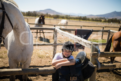 Smiling girl leaning on the fence in ranch