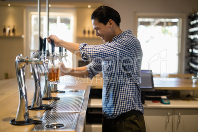 Bar tender filling beer from beer pump