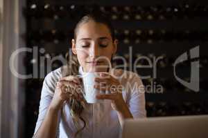 Smiling woman having coffee in cafe