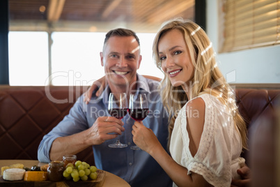 Happy couple holding wine glass while having meal