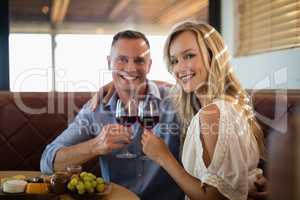 Happy couple holding wine glass while having meal