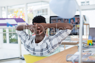 Male executive relaxing at his desk in office