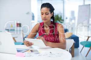 Female graphic designer using graphic tablet at desk