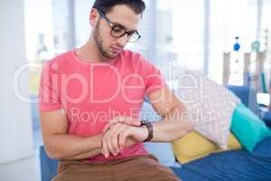 Male executive checking time on smartwatch