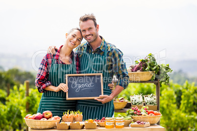 Portrait of couple holding blackboard with text